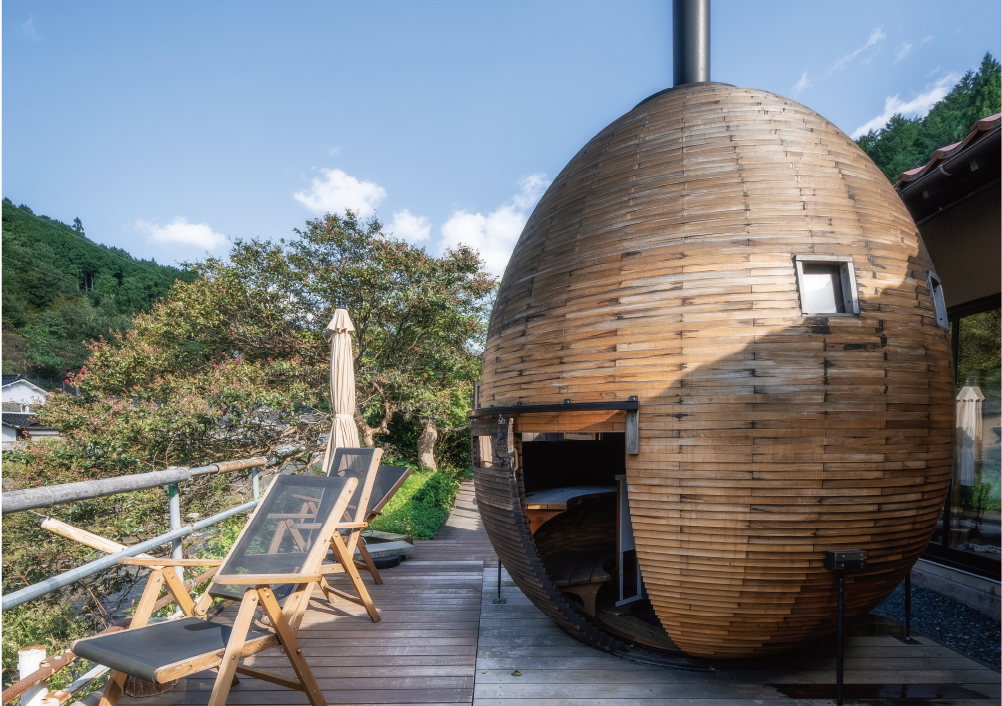 薪で沸かしたお湯と掛け流しの源泉(冷泉)の温冷交代浴は、サウナのような整う感覚が得られると評判。卵形のデザインがユニークな貸切サウナスペース、焚き火料理が楽しめる客室など、ローカル・エネルギーである薪をエンタメとして提供している施設だ