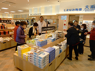 売店商品などの説明を聞く参加者